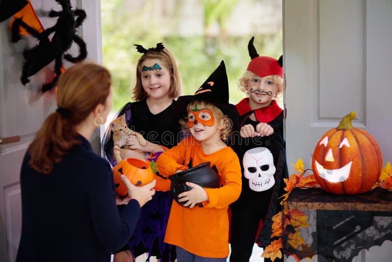 Six adults and two kids standing together on a front porch wearing matching black capes over their own clothes with small different masks